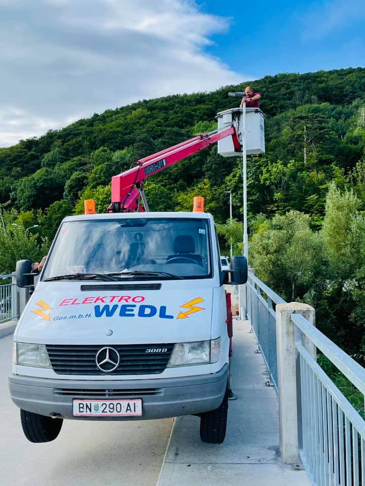Elektro Wedl im Einsatz: Mannschaftsfahrzeug mit Hubsteiger bei Arbeiten an einer Brückenbeleuchtung